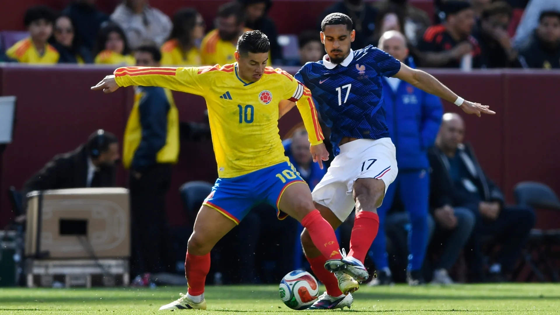James Rodríguez of Colombia is challenged by Maxence Lacroix of France.