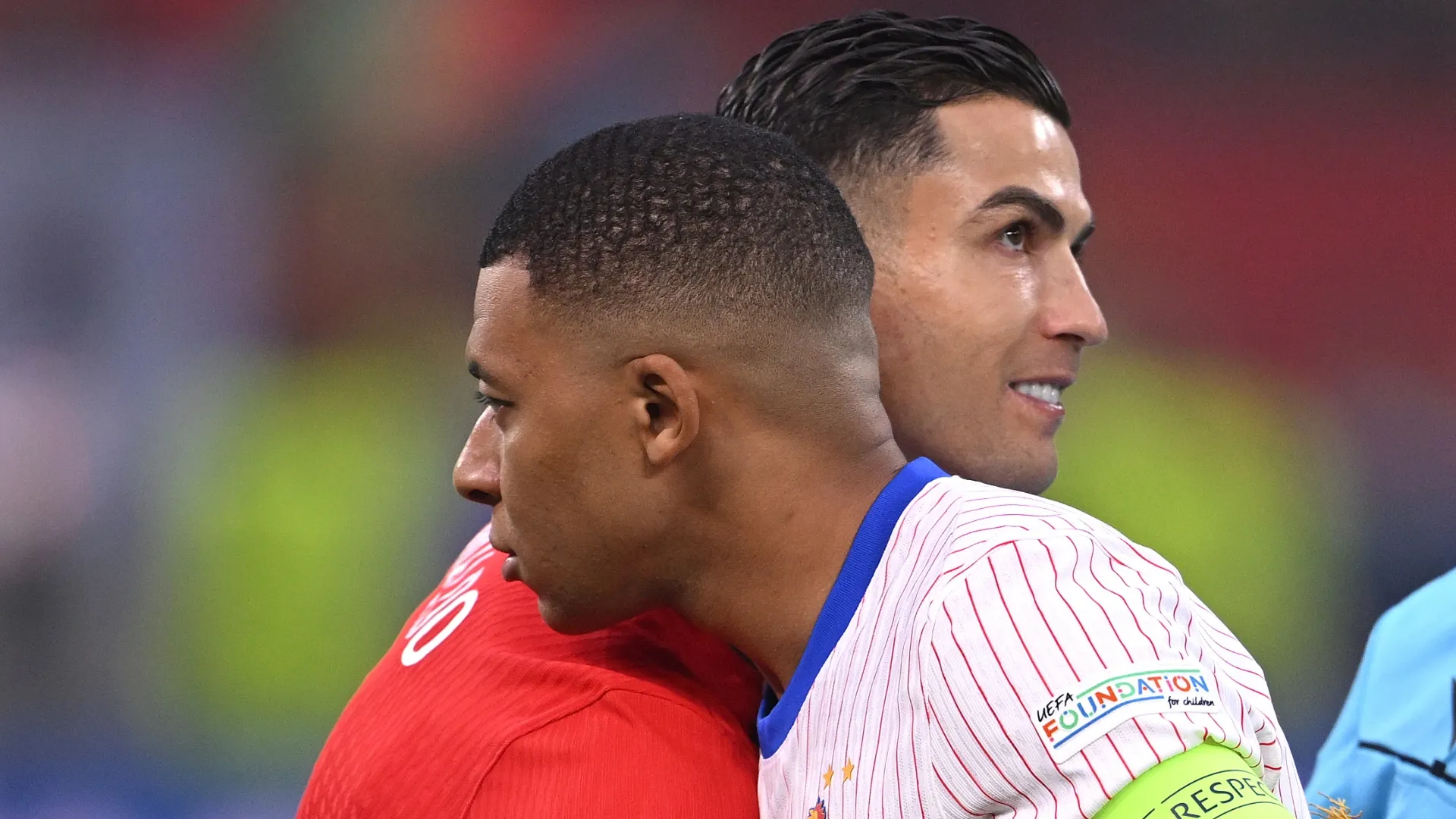 Cristiano Ronaldo embraces with Kylian Mbappe as they exchange pennants prior to a match between Portugal and France.