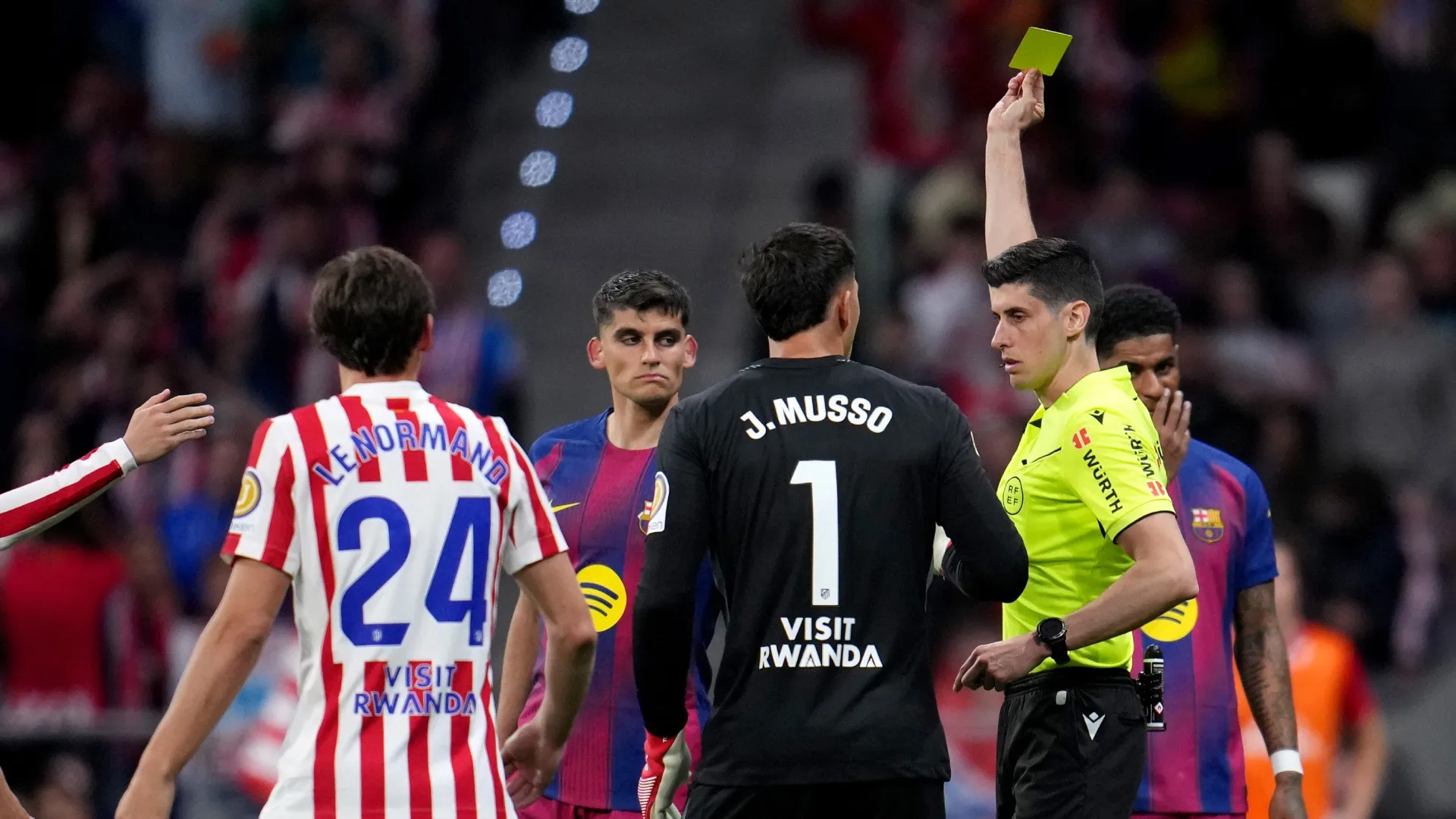 Referee Mateo Busquets Ferrer shows a yellow card to Gerard Martin of FC Barcelona after changing it from a red card following a VAR review.