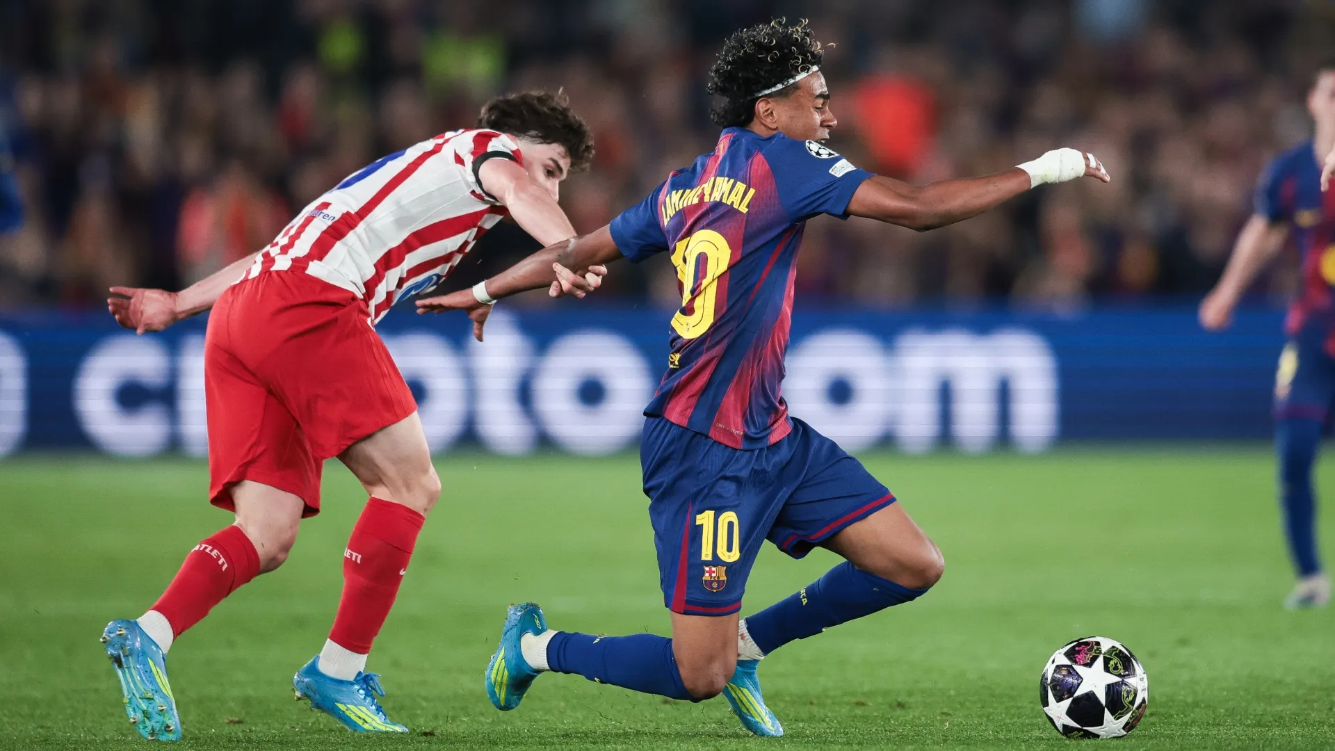 Lamine Yamal of FC Barcelona is tackled by Julian Alvarez of Atletico Madrid.