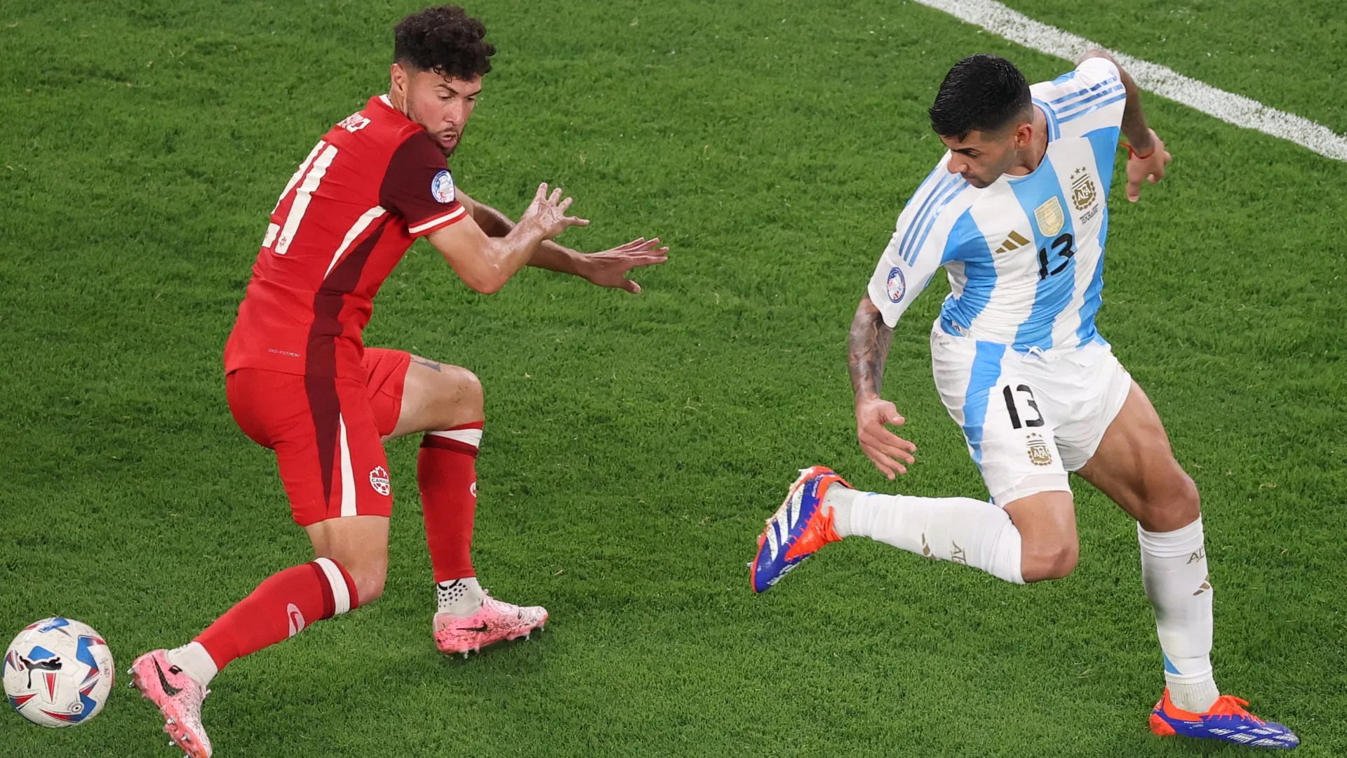 Cristian Romero of Argentina fights for the ball with Jonathan Osorio of Canada.