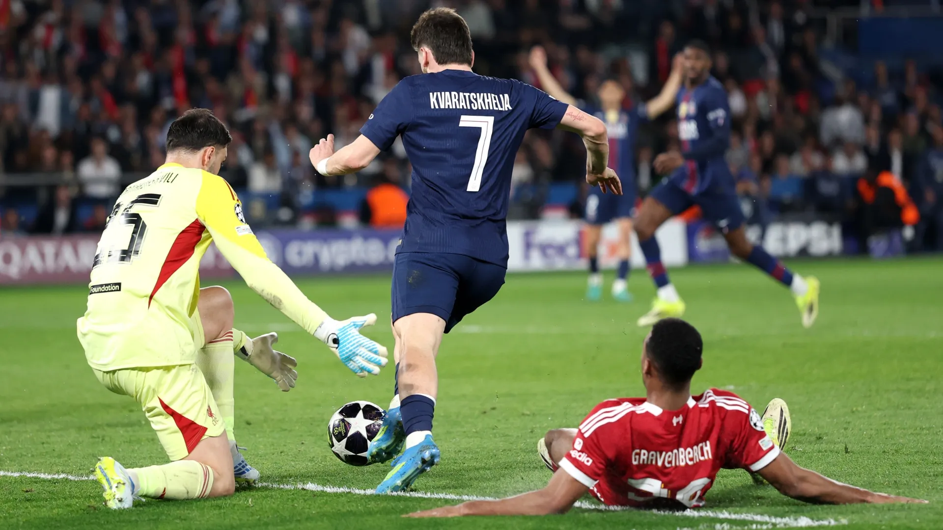 Khvicha Kvaratskhelia of Paris Saint-Germain goes around Giorgi Mamardashvili of Liverpool to score a goal.