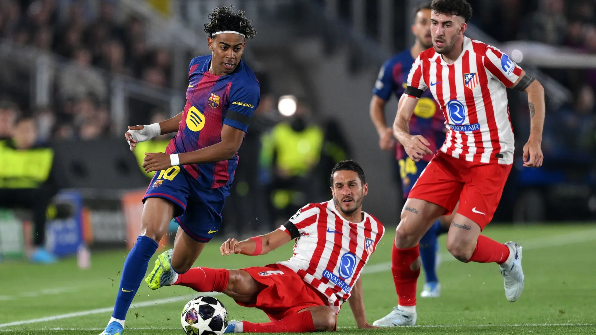 Lamine Yamal of FC Barcelona is challenged by Koke of Atletico de Madrid.