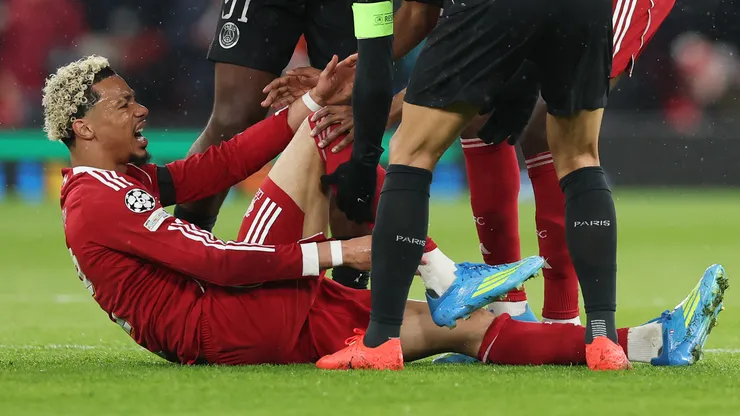 Hugo Ekitike of Liverpool holds his ankle as he appears to be injured