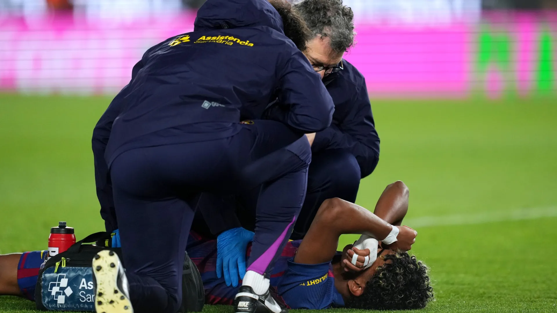 Lamine Yamal of FC Barcelona reacts to an injury after scoring.