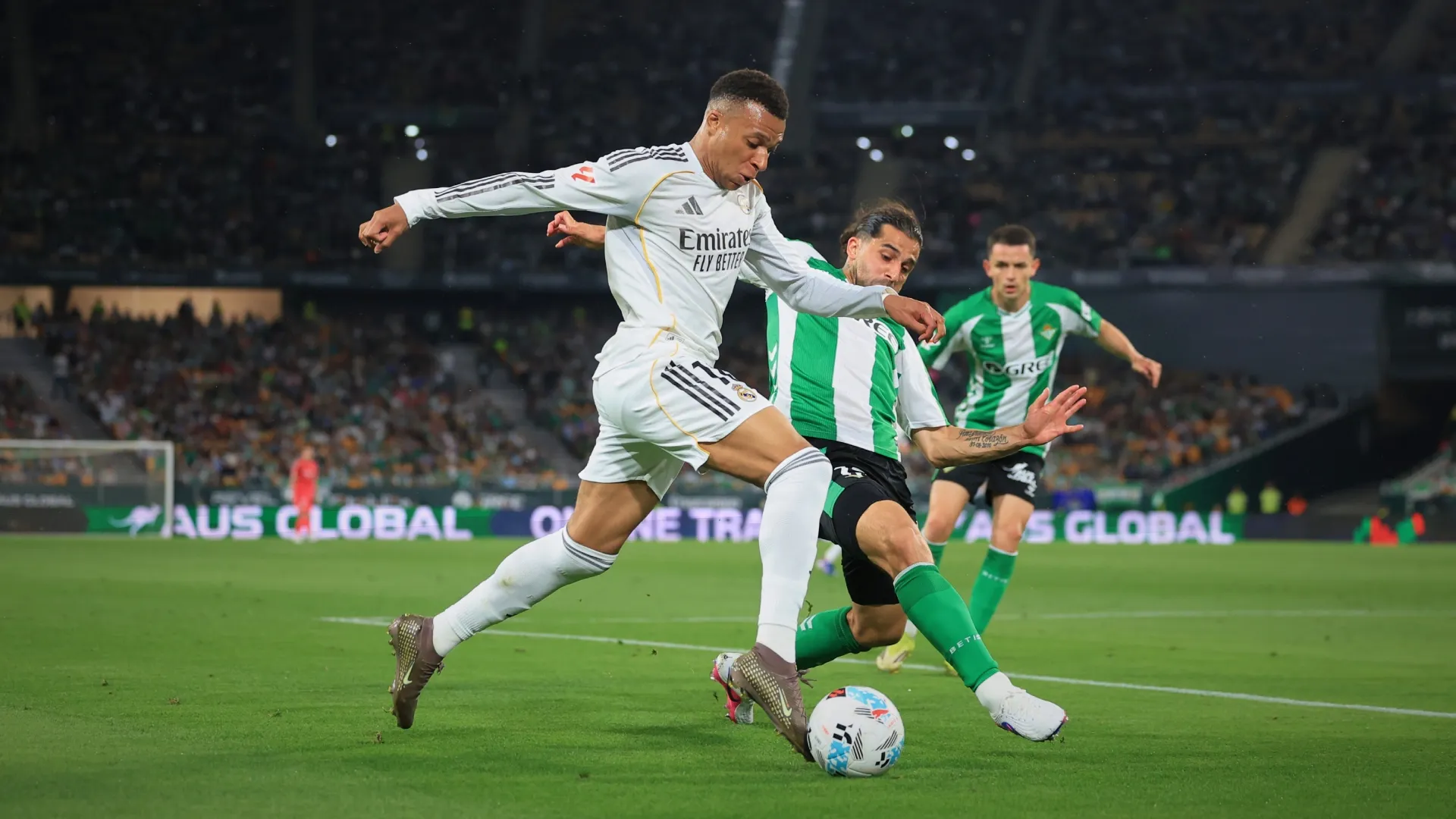 Kylian Mbappe of Real Madrid runs with the ball while under pressure from Ricardo Rodriguez of Real Betis.