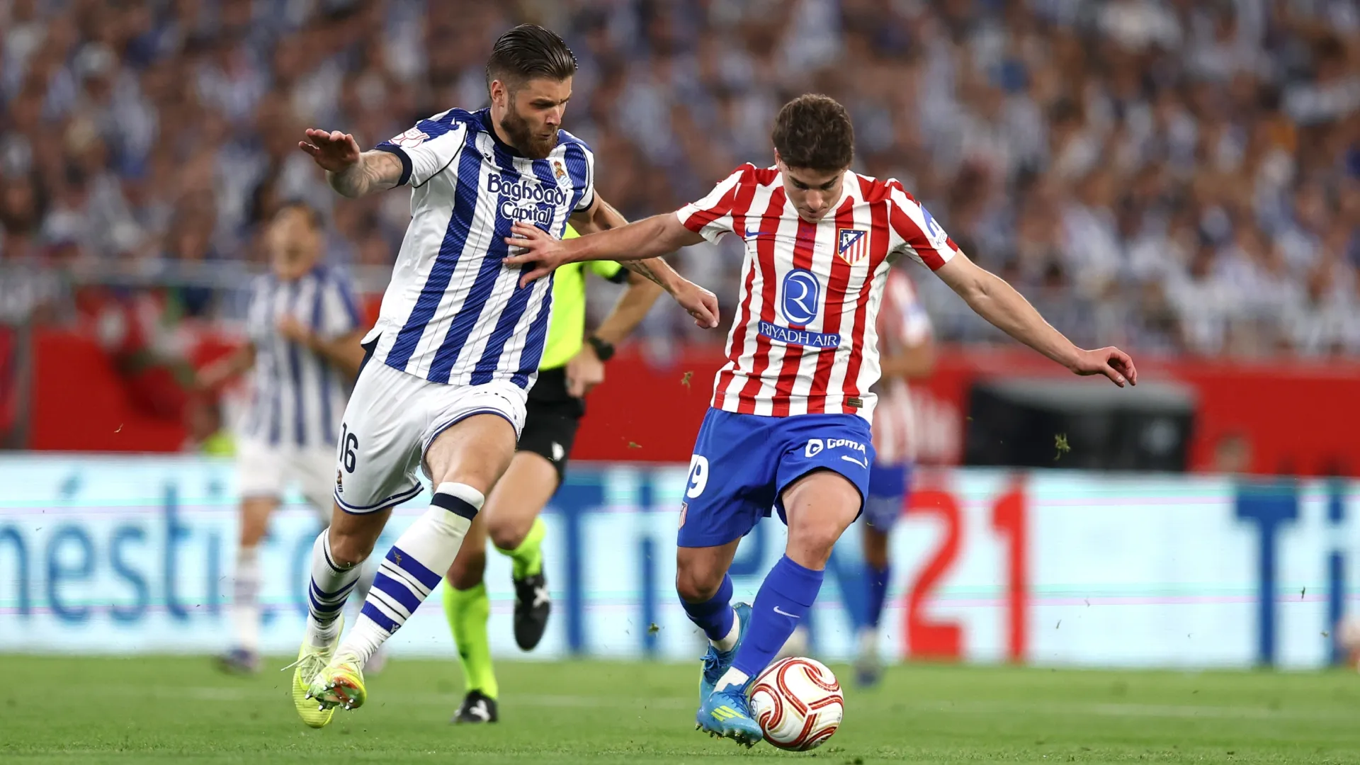 Julian Alvarez of Atletico de Madrid runs with the ball whilst under pressure from Duje Caleta-Car of Real Sociedad.