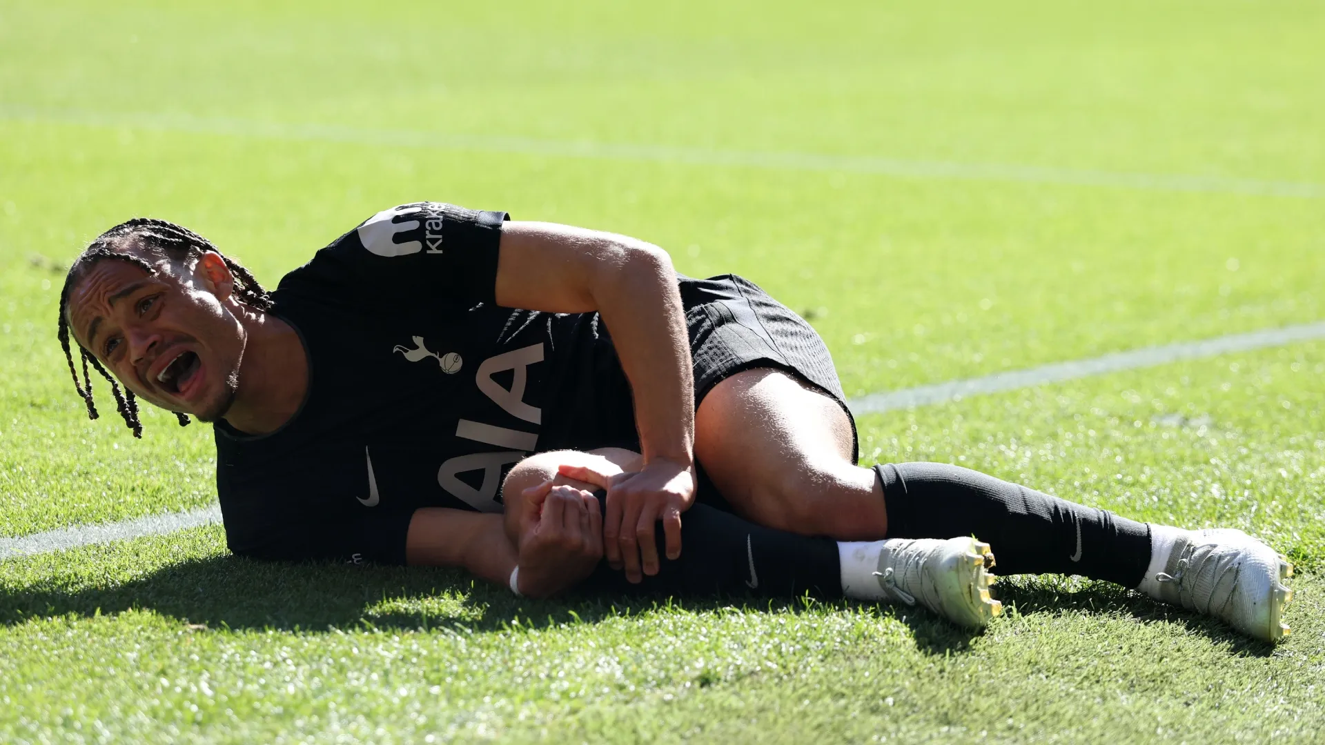 Xavi Simons of Tottenham Hotspur reacts on the floor with a injury during the Premier League.
