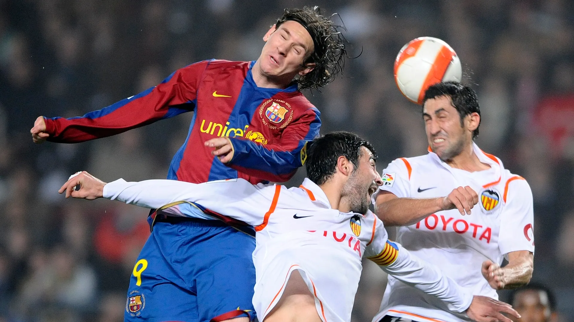 Lionel Messi (L) of Barcelona duels for the ball with Raul Albiol (C) and Marco Caneira (R) of Valencia.