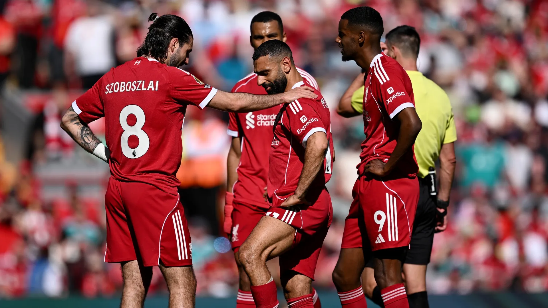 Mohamed Salah of Liverpool is helped by teammate Dominik Szoboszlai as he reacts with an injury.