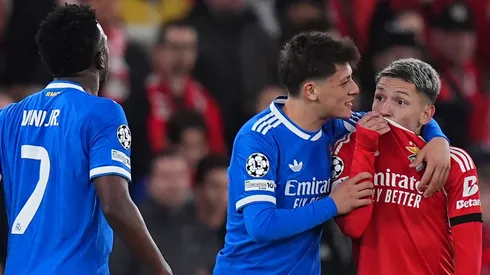 Gianluca Prestianni of Benfica speaks towards Vinicius Junior of Real Madrid covering his mouth.
