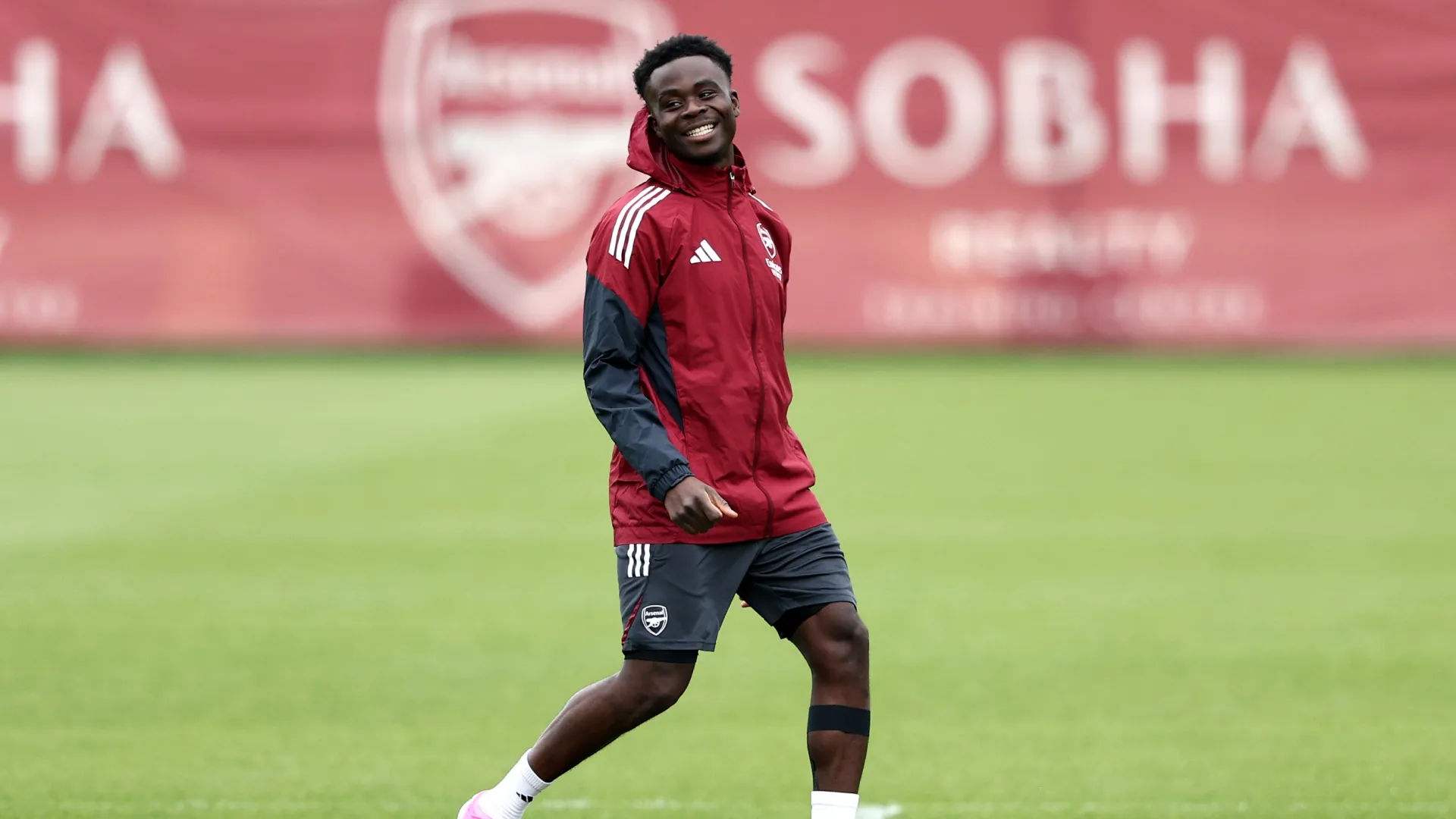Bukayo Saka of Arsenal smiles during a training session.