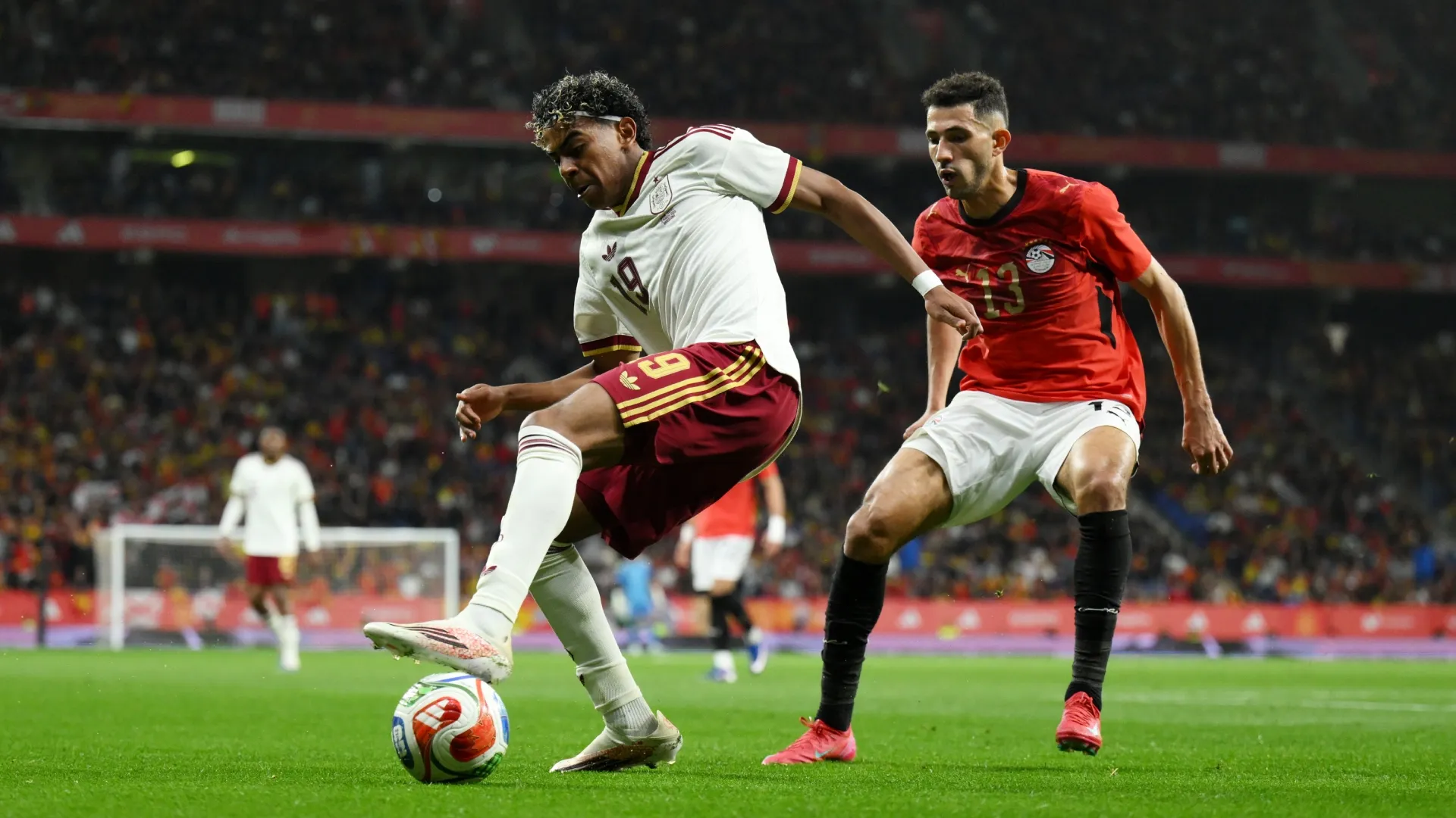 Lamine Yamal of Spain controls the ball while under pressure from Ahmed Fatouh of Egypt.