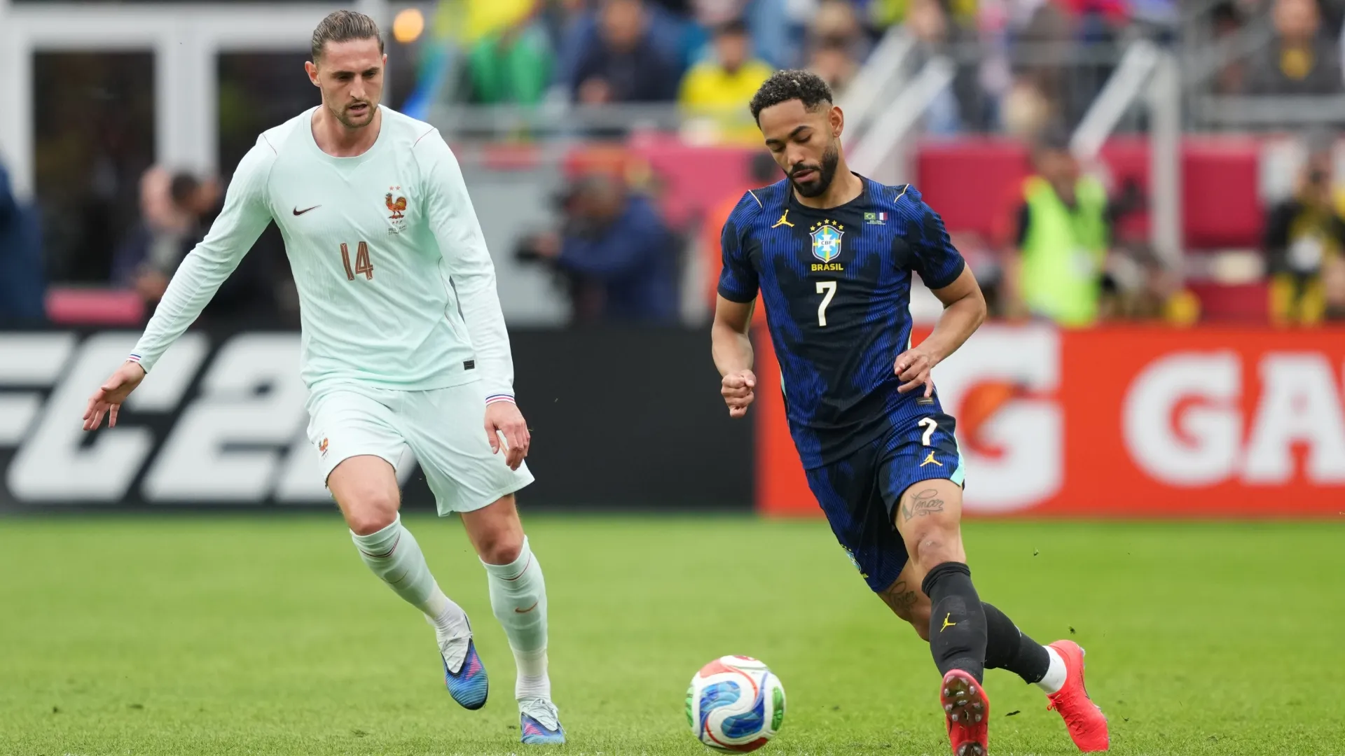 Matheus Cunha of Brazil runs with the ball against Adrien Rabiot of France.