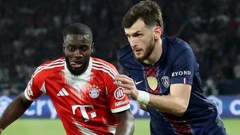 Khvicha Kvaratskhelia of PSG runs with the ball against Dayot Upamecano of Bayern München.