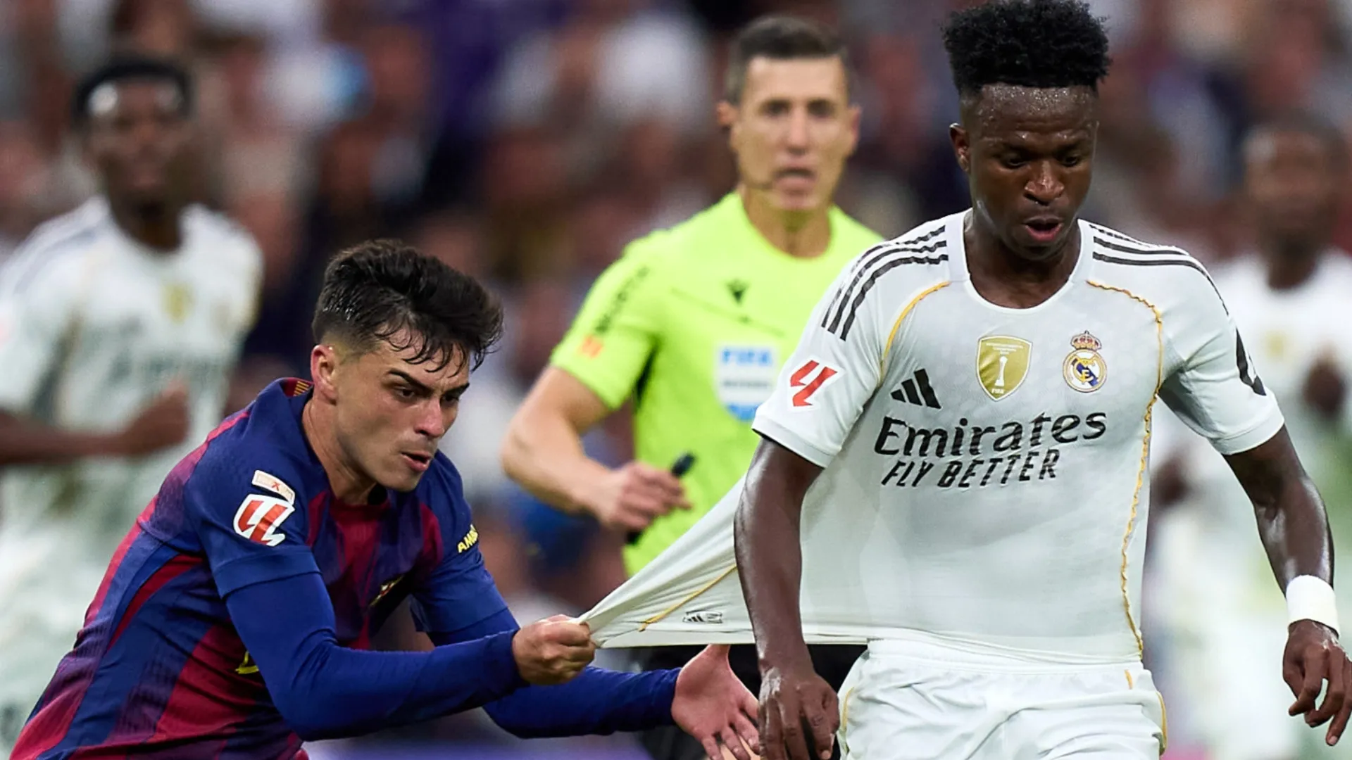Vinicius Junior of Real Madrid is challenged by Pedri of FC Barcelona.