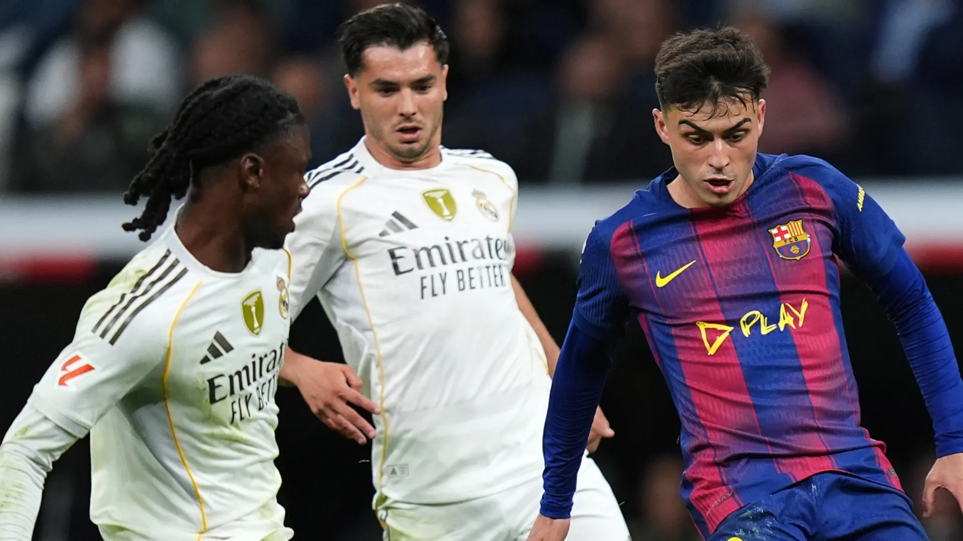 Pedri of FC Barcelona controls the ball whilst under pressure from Eduardo Camavinga of Real Madrid.