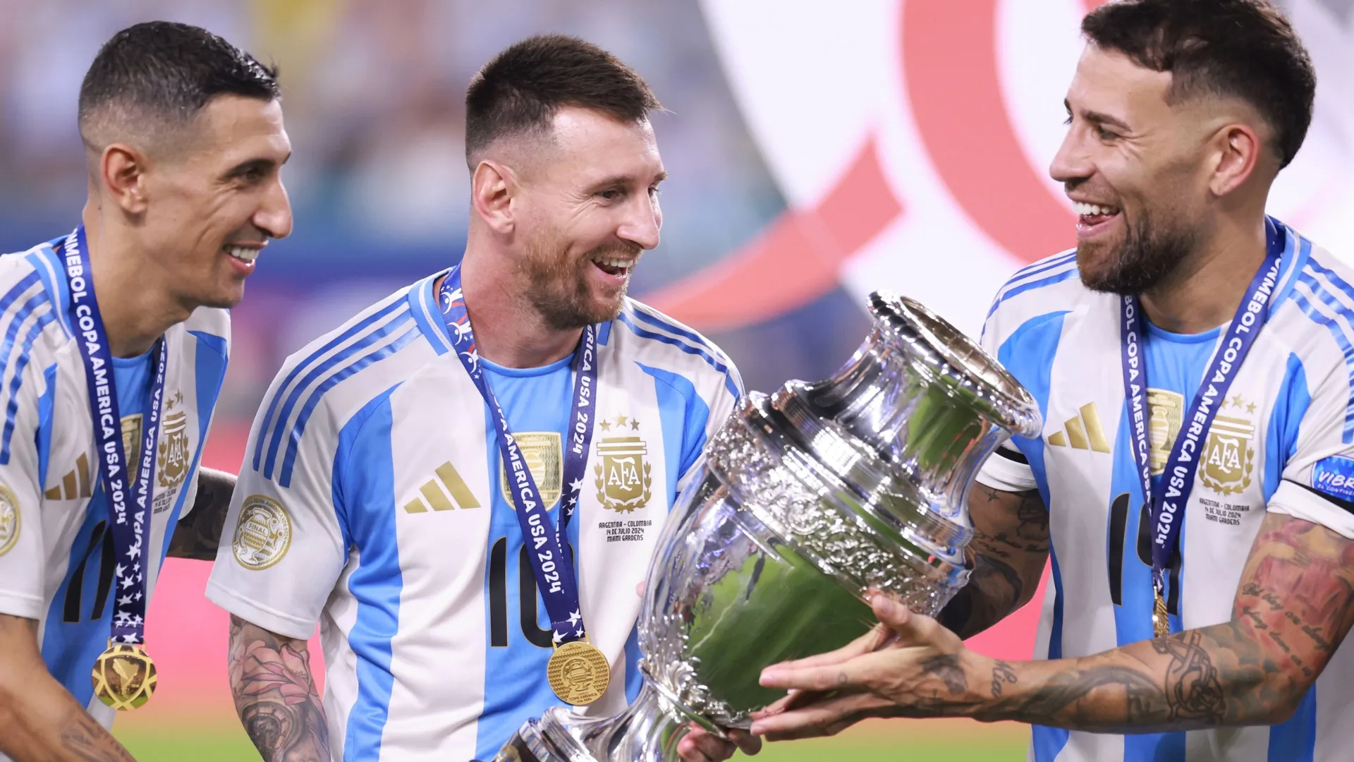 Angel Di Maria, Lionel Messi and Nicolas Otamendi of Argentina celebrate with the trophy.