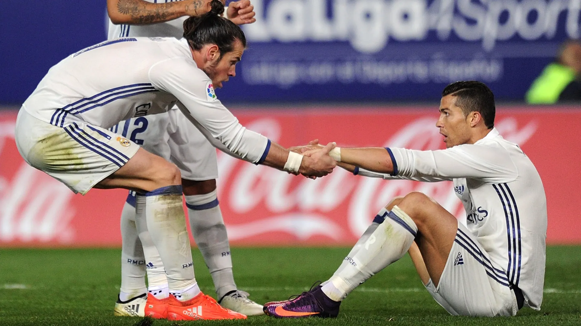Cristiano Ronaldo of Real Madrid CF is helped up by teammate Gareth Bale.