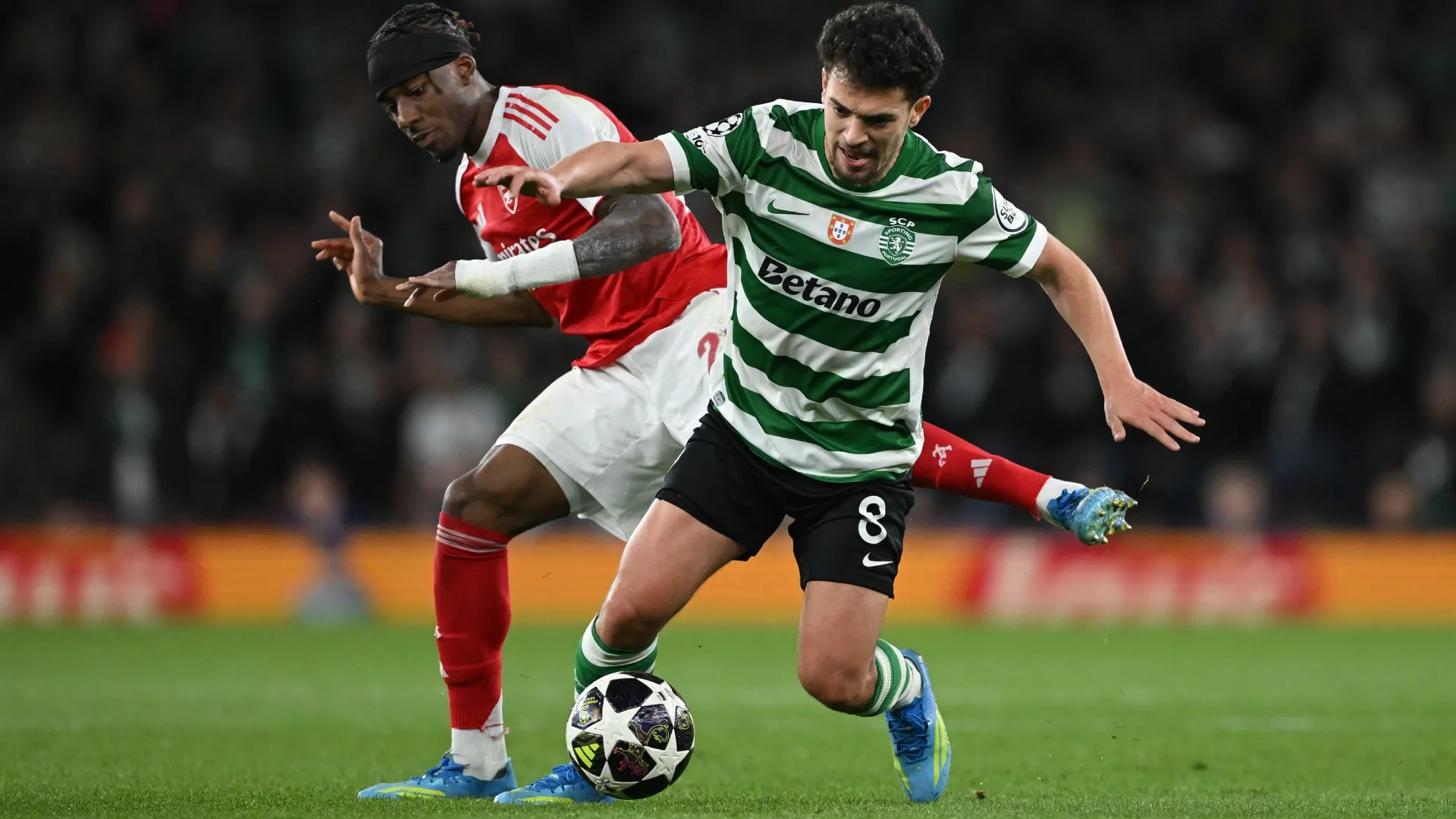 Pedro Goncalves of Sporting Clube de Portugal runs with the ball whilst under pressure from Noni Madueke of Arsenal.
