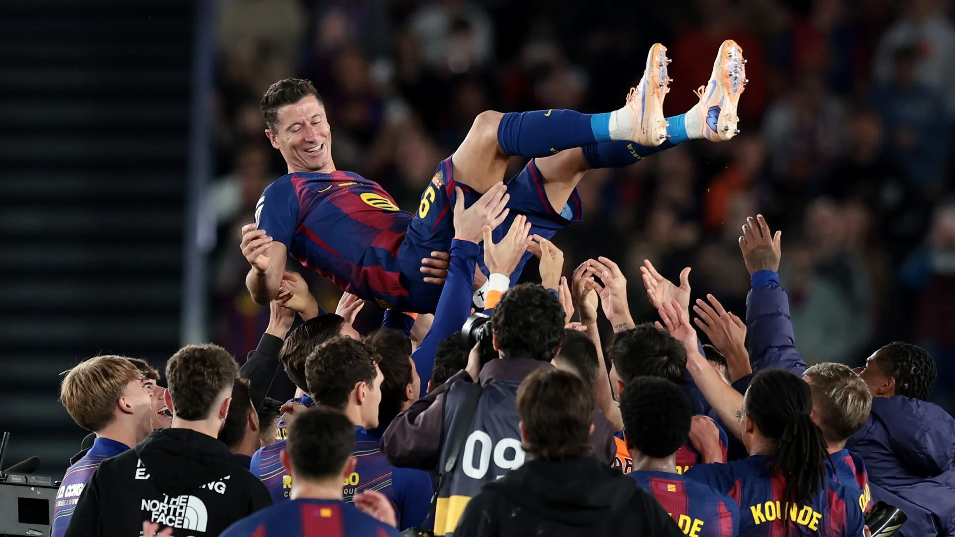 Robert Lewandowski of FC Barcelona is hoisted by teammates.