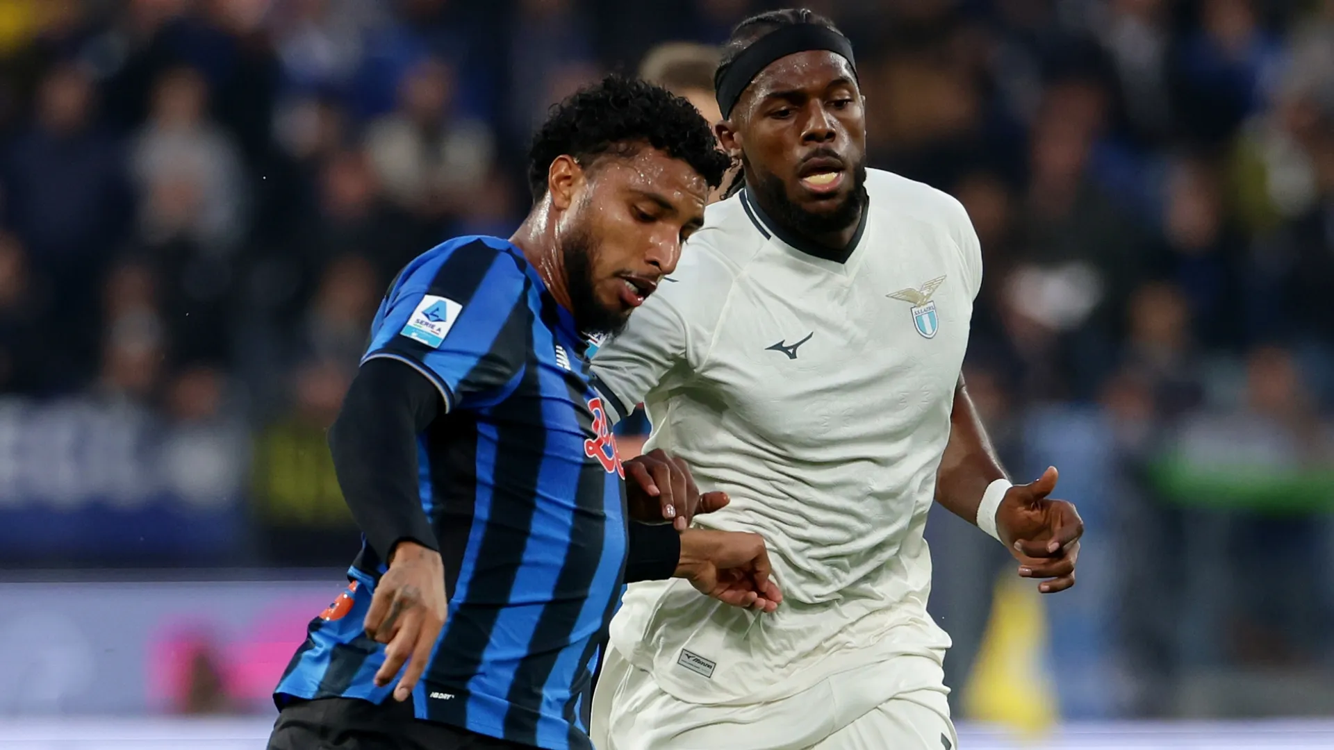 Ederson of Atalanta BC passes the ball under pressure from Nuno Tavares of Lazio.