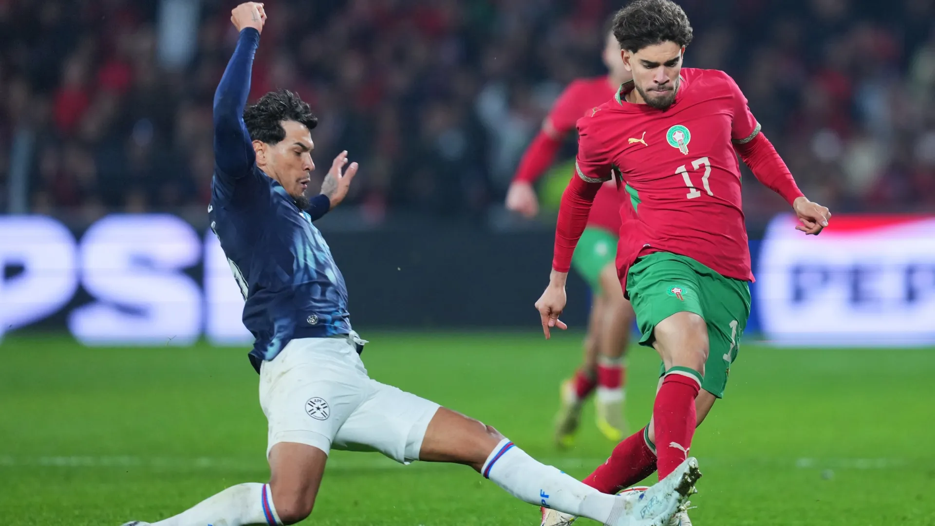 Abdessamad Ezzalzouli of Morocco is challenged by Gustavo Gomez of Paraguay.