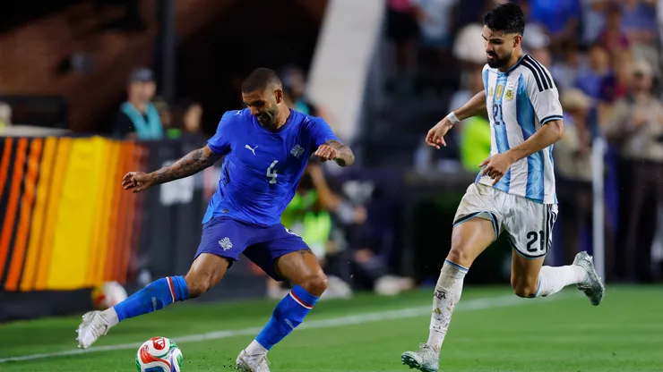 Gudiagur Palsson of Iceland dribbles the ball against Juan Manuel Lopez of Argentina.