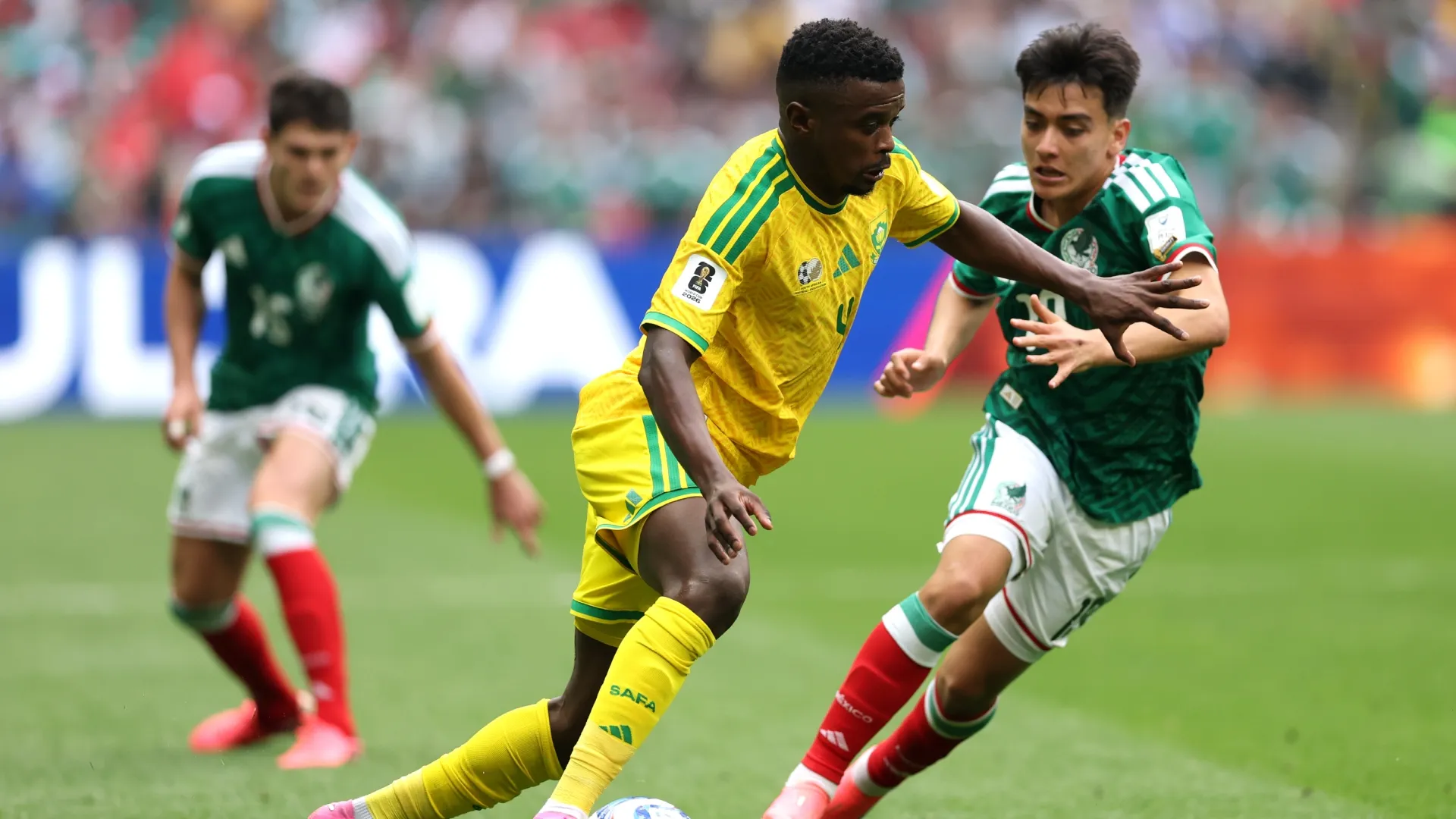 Teboho Mokoena #4 of South Africa is challenged by Gilberto Mora #19 of Mexico.