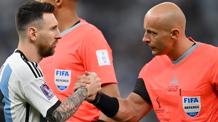 Lionel Messi of Argentina shakes hands with referee Szymon Marciniak.