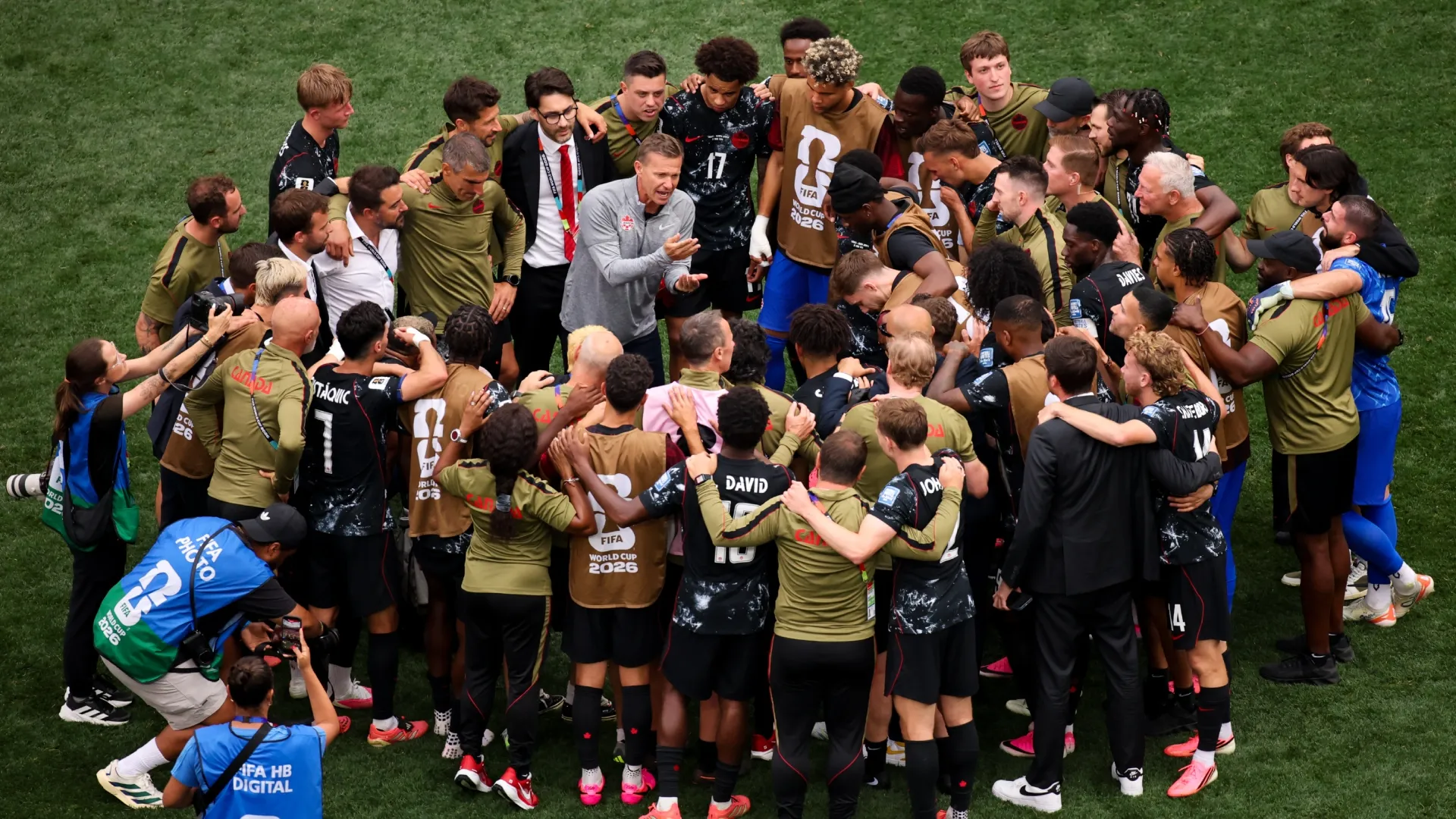 Jesse Marsch, Head Coach of Canada, speaks with his players in a huddle after the team's victory.