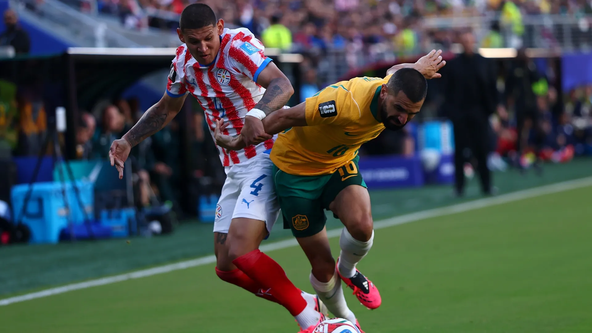 Juan Jose Caceres of Paraguay battles for the ball with Aziz Behich of Australia.