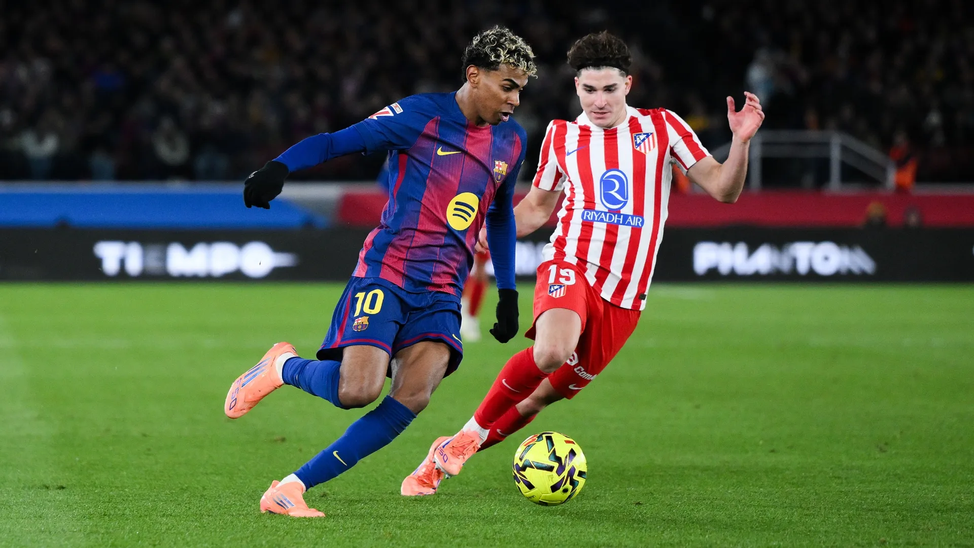 Lamine Yamal of FC Barcelona competes for the ball with Julian Alvarez of Atletico Madrid.