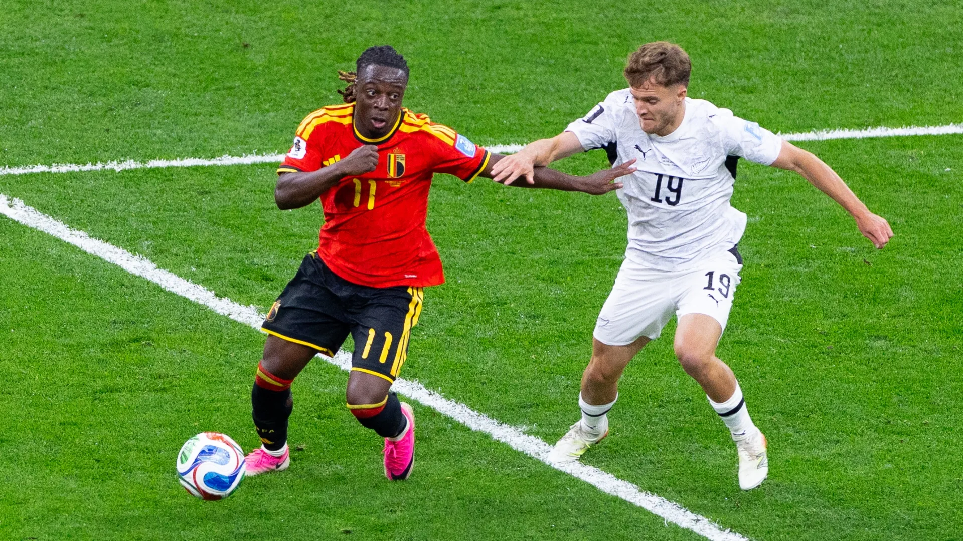 Ben Old of New Zealand competes for the ball with Jeremy Doku of Belgium.