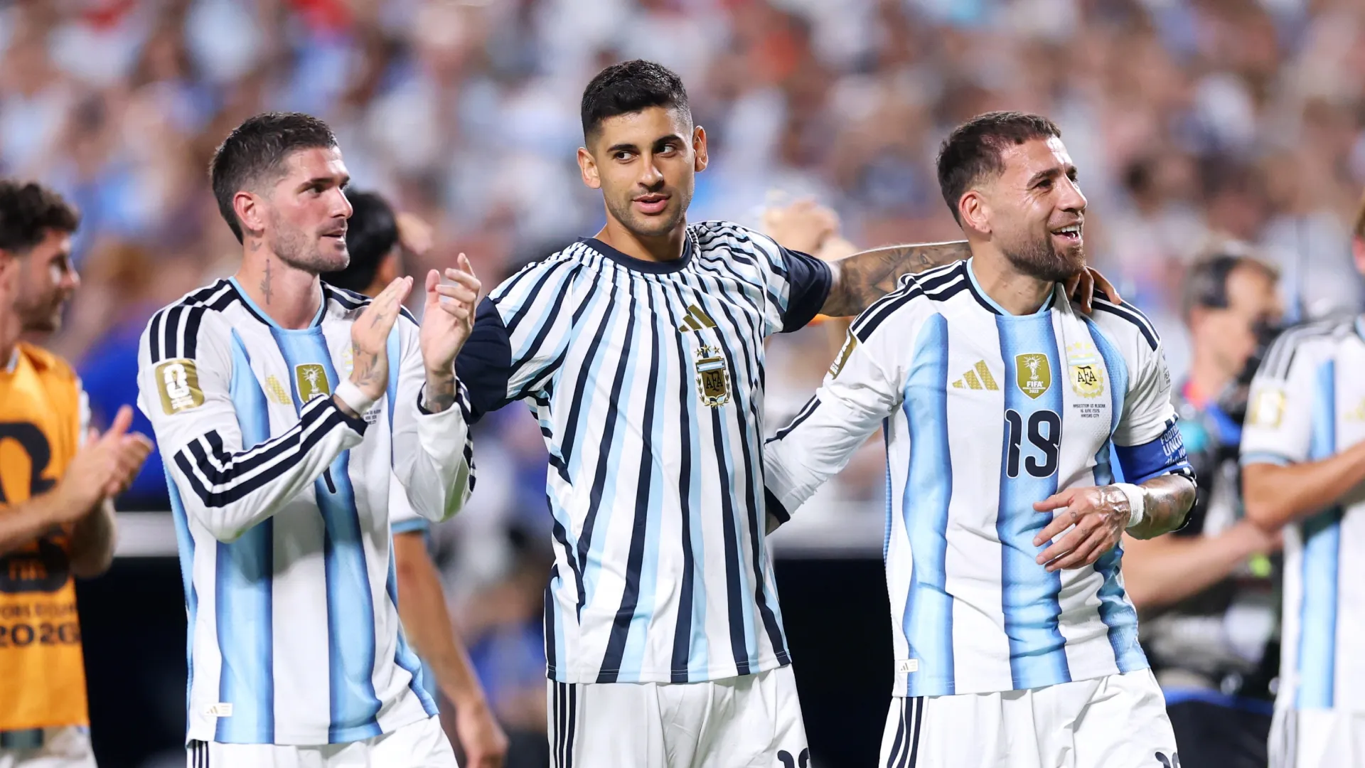 Rodrigo De Paul #7, Cristian Romero #13 and Nicolas Otamendi #19 of Argentina applaud fans.