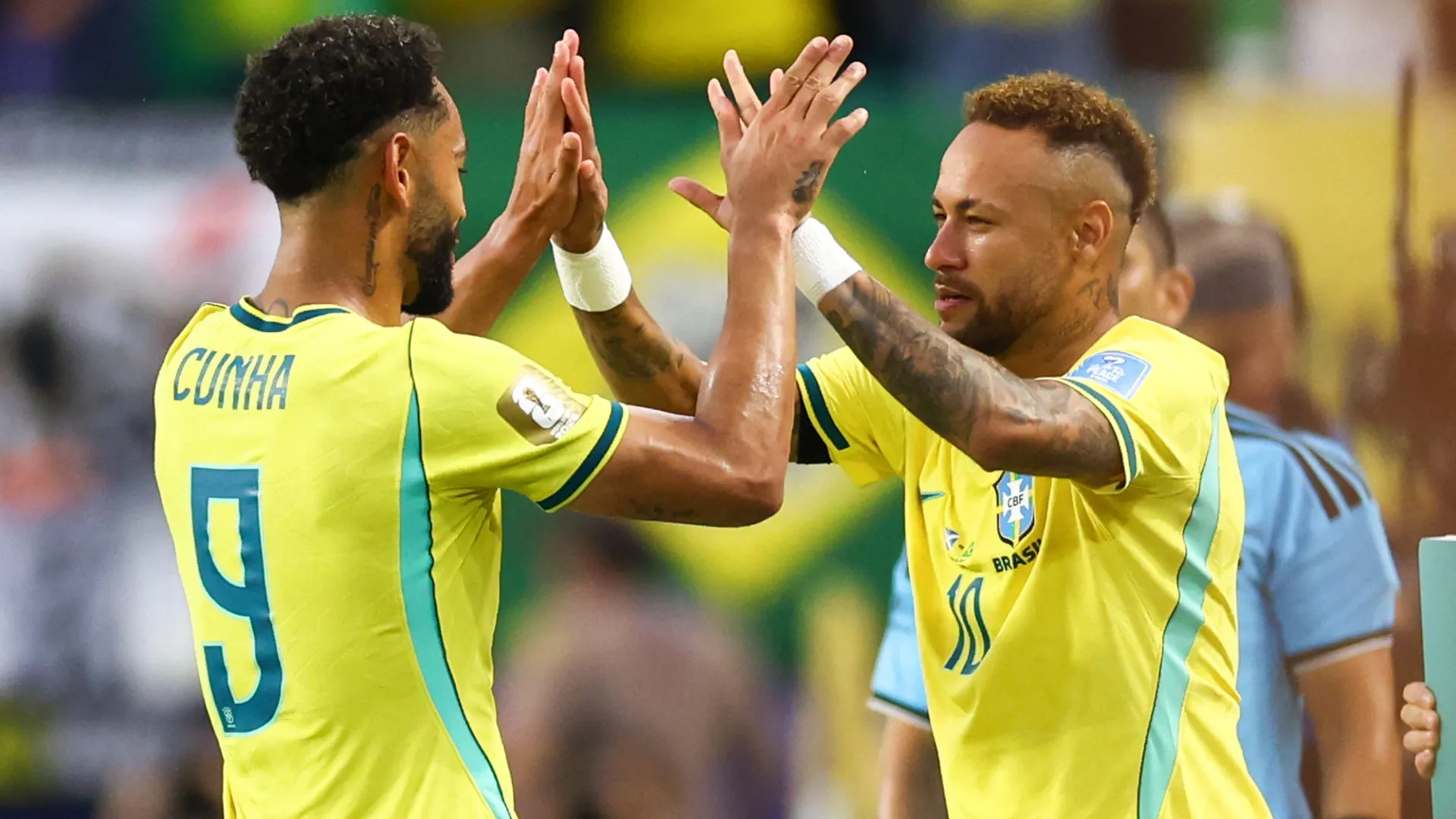 Neymar Jr #10 of Brazil embraces Matheus Cunha #9.
