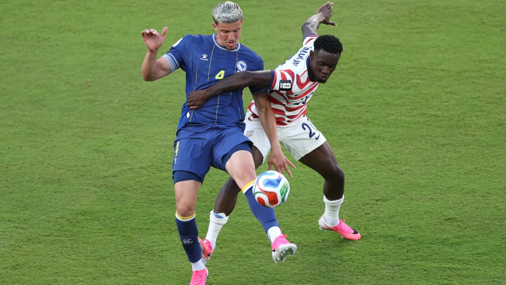 Folarin Balogun #20 of the United States fouls Tarik Muharemovic #4 of Bosnia and Herzegovina.