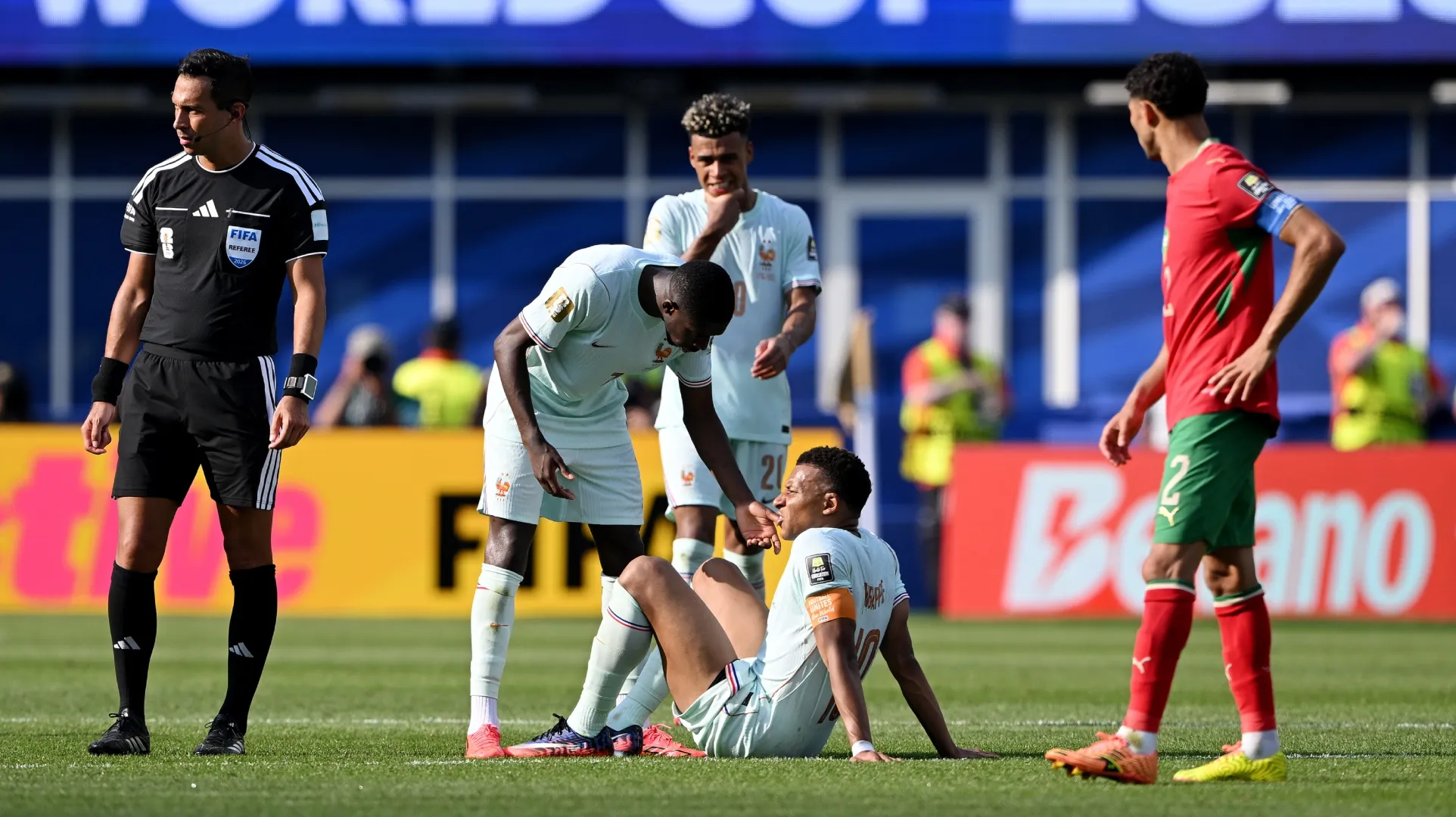 Kylian Mbappe #10 of France is attended to by teammates.