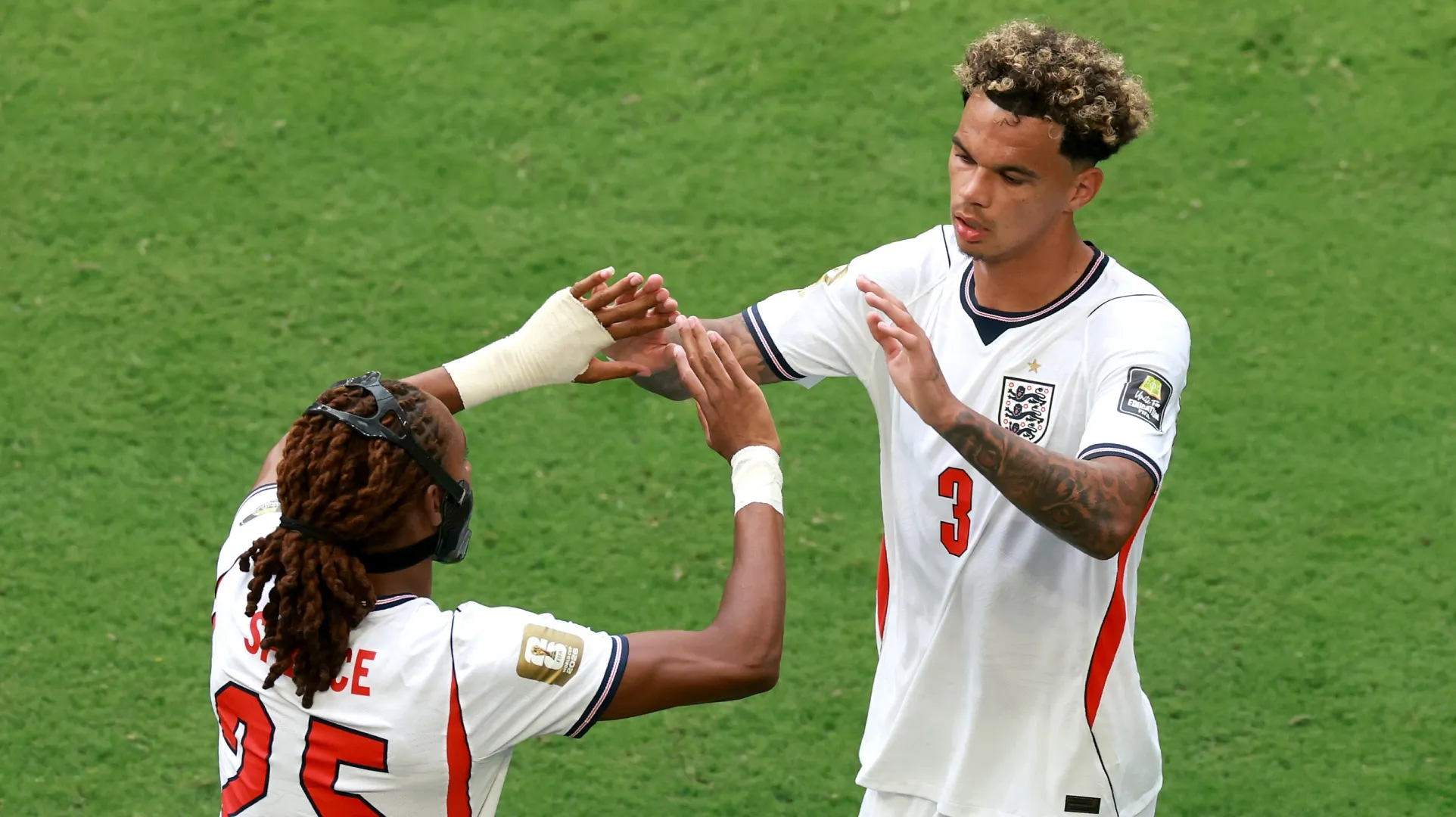 Nico O'Reilly #3 of England high fives Djed Spence #25 as he is substituted.