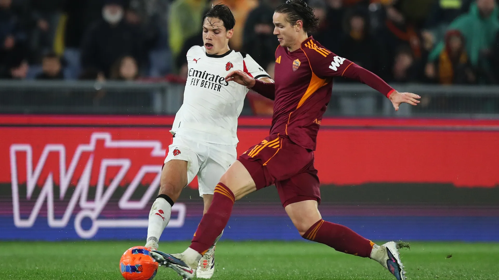 Samuele Ricci of AC Milan battles for possession with Daniele Ghilardi of AS Roma.