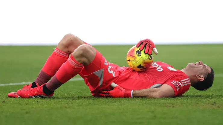 Aston Villa goalkeeper Emiliano Martinez clutches his back in apparent agony after a clash with Yoane Wissa.