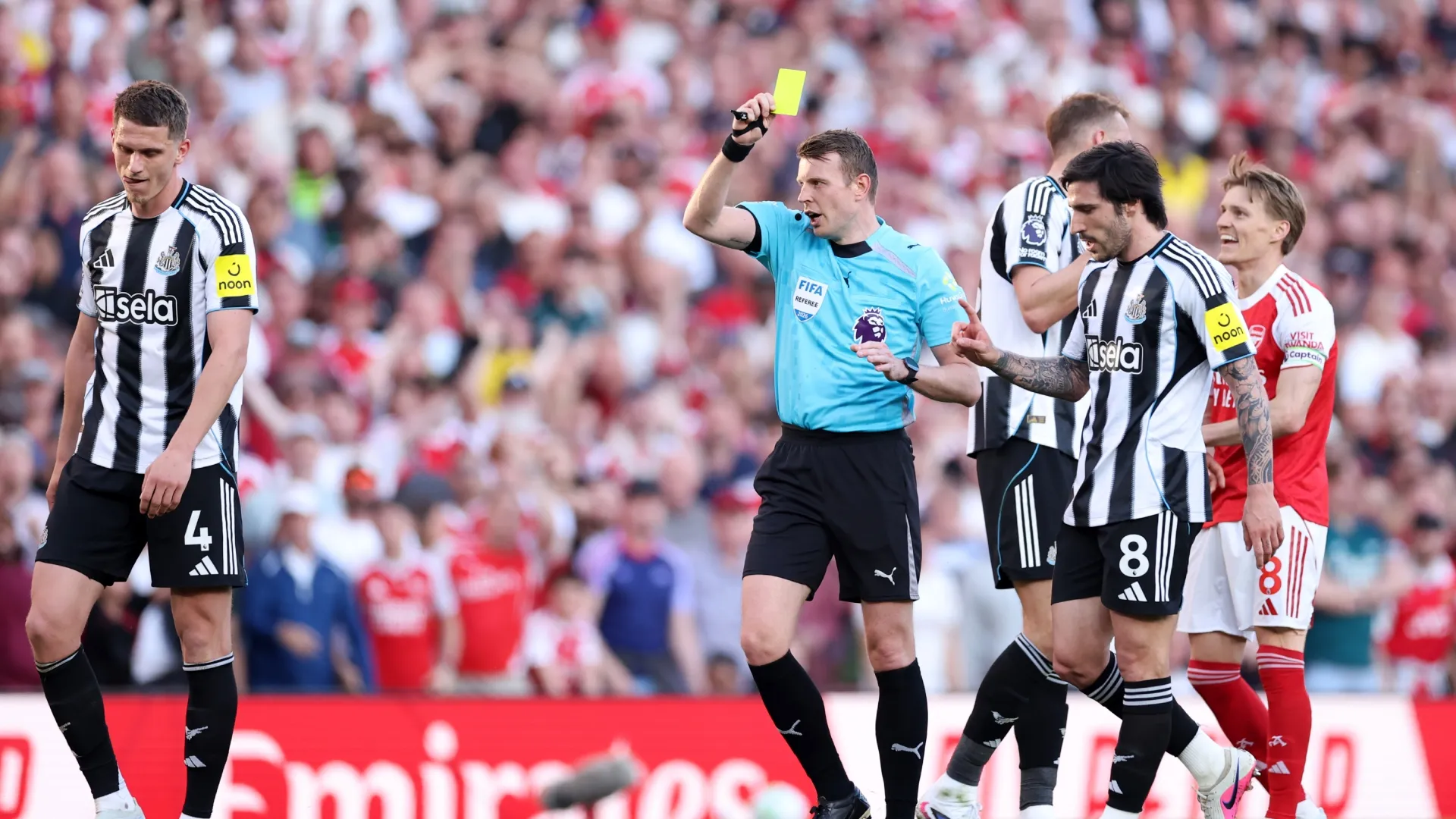 Referee Sam Barrott shows Nick Pope of Newcastle United a yellow card during the Premier League clash vs. Arsenal
