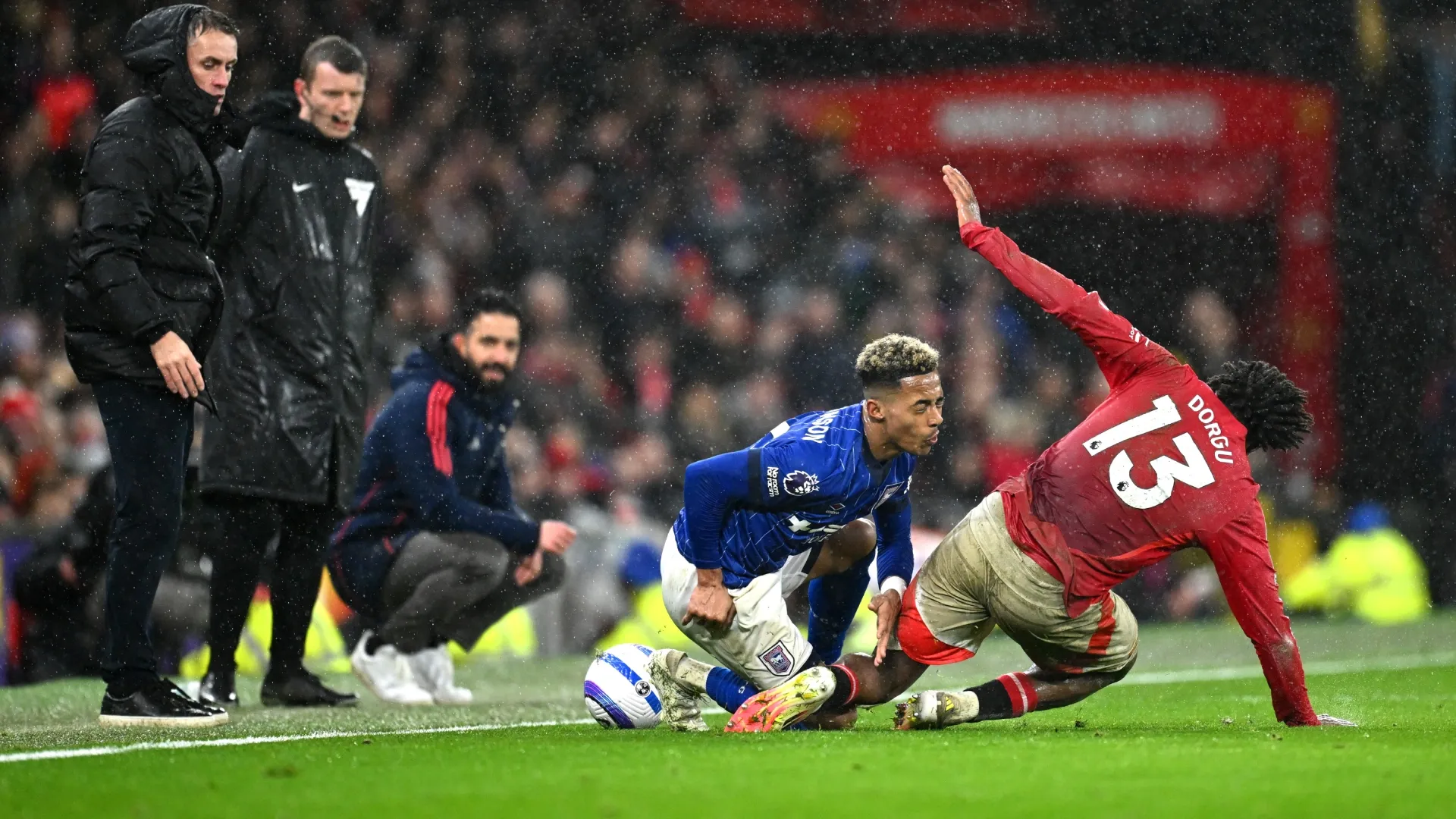 Omari Hutchinson of Ipswich Town is fouled by Patrick Chinazaekpere Dorgu of Manchester United, with Ruben Amorim on the background.