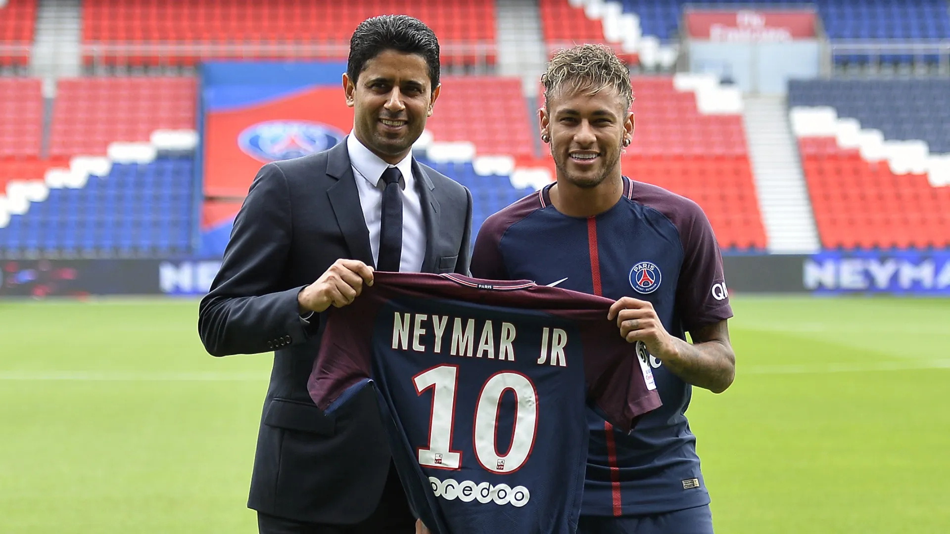 Neymar poses with Paris Saint-Germain's jersey next to president Nasser Al-Khelaifi.