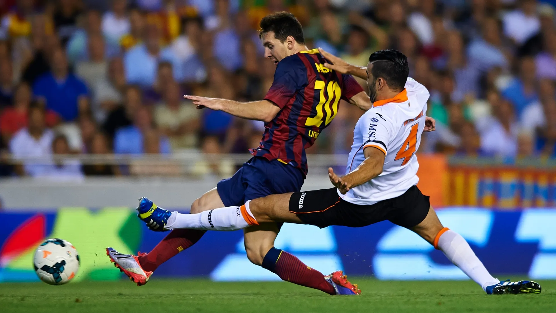 Lionel Messi (L) of Barcelona shoots for score in front of Adil Rami of Valencia.