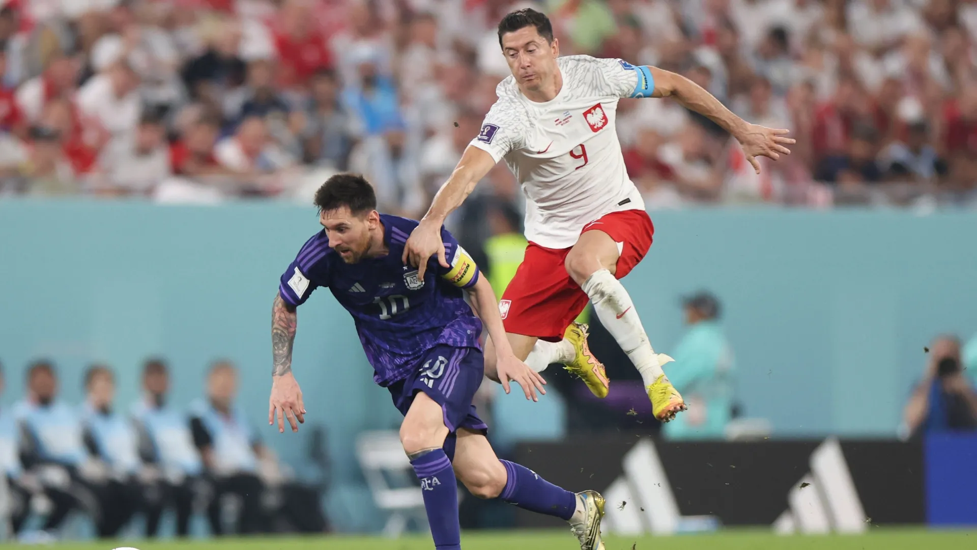 Lionel Messi of Argentina battles for possesion with Robert Lewandowski of Poland.
